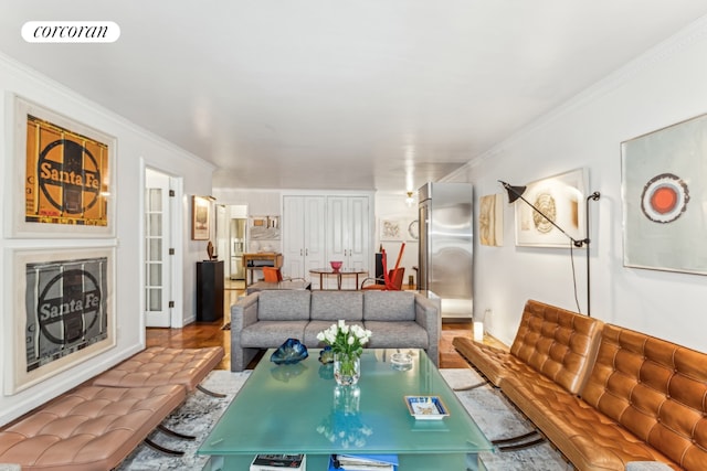 living area with a fireplace, visible vents, crown molding, and wood finished floors