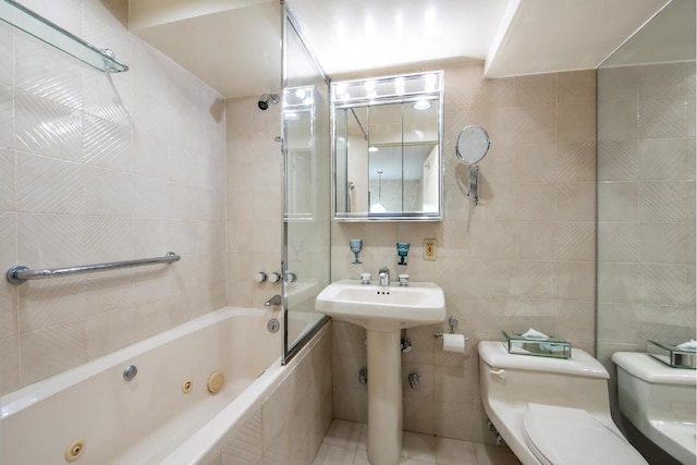 bathroom with toilet, tile patterned flooring, tile walls, and bathing tub / shower combination