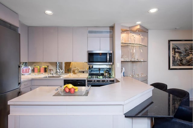 kitchen featuring a breakfast bar area, stainless steel appliances, a center island, and sink