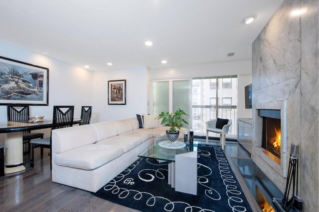 living room with dark wood-type flooring and a fireplace