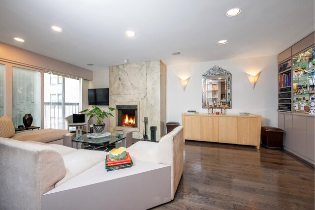 living room featuring a premium fireplace and dark hardwood / wood-style floors