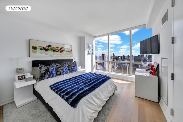 bedroom featuring hardwood / wood-style floors and expansive windows