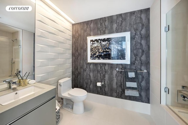 bathroom featuring toilet, tile patterned flooring, tile walls, walk in shower, and vanity