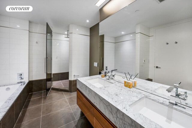 kitchen featuring white cabinetry, an island with sink, sink, light wood-type flooring, and light stone counters