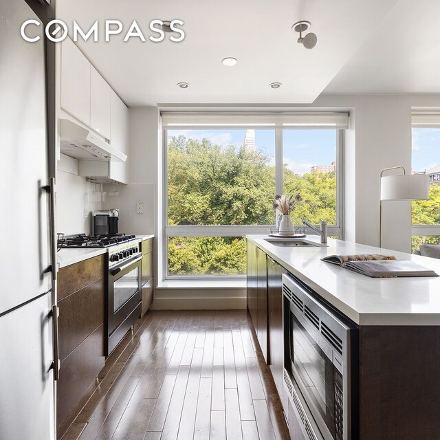 kitchen with decorative backsplash, white cabinetry, appliances with stainless steel finishes, and a wealth of natural light