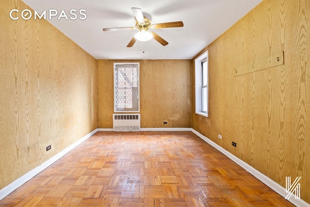 unfurnished room featuring ceiling fan, radiator heating unit, and baseboards