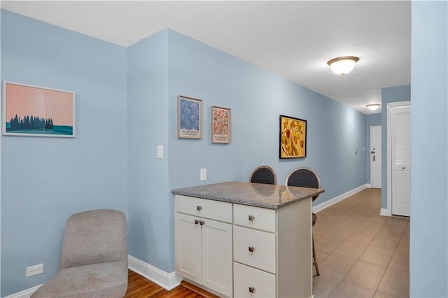 221 Mcdonald Ave Unit P3, New York City, NY 11218 - kitchen featuring a breakfast bar area, white cabinetry, a peninsula, and light tile patterned floors