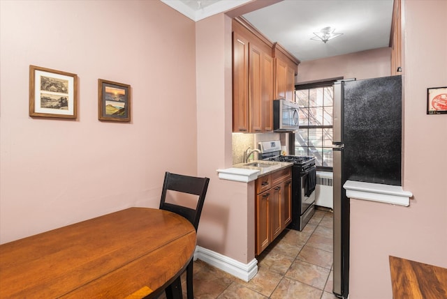 kitchen with brown cabinets, stainless steel appliances, light countertops, light tile patterned floors, and decorative backsplash