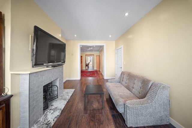 living room featuring dark hardwood / wood-style flooring and a brick fireplace