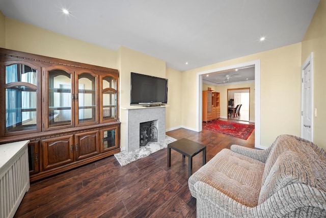 living room featuring a brick fireplace and dark hardwood / wood-style floors