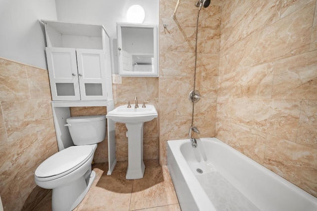 bathroom with tile patterned floors, tile walls, toilet, and shower / washtub combination