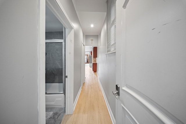 hallway with light wood-type flooring and baseboards