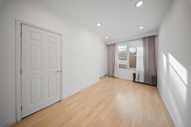 empty room with baseboards, light wood-type flooring, and recessed lighting