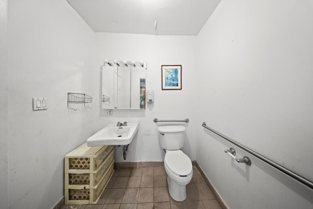 bathroom featuring sink, tile patterned floors, and toilet