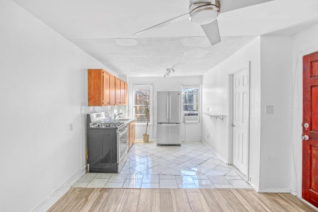 kitchen featuring stainless steel appliances, sink, and ceiling fan