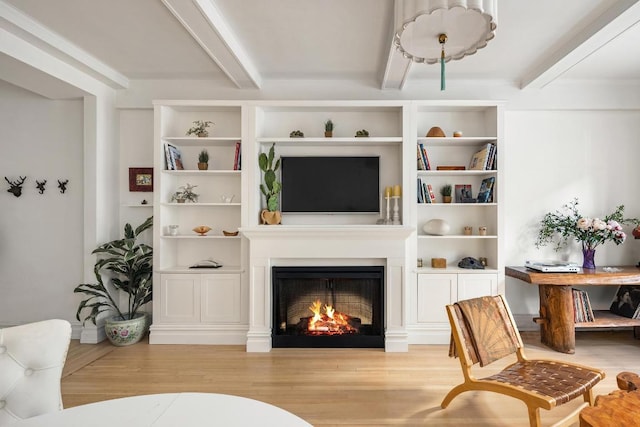 living room with beamed ceiling and light wood-type flooring