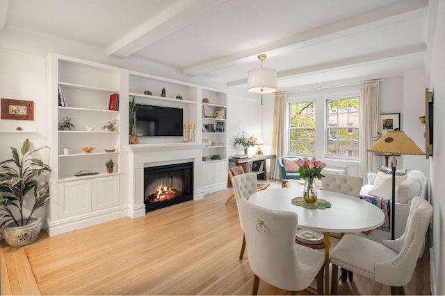 dining area with light wood-type flooring and beam ceiling