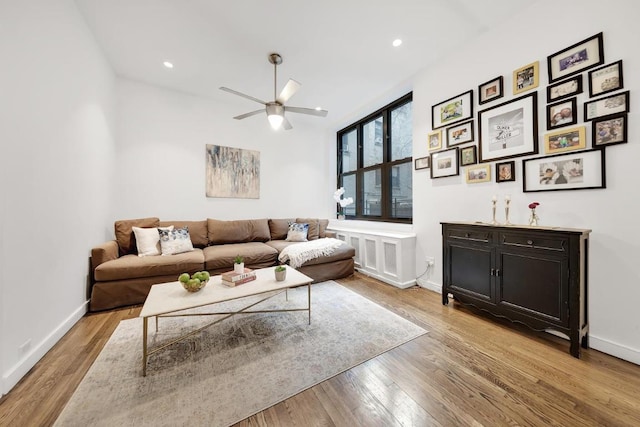 living room featuring ceiling fan and light hardwood / wood-style flooring