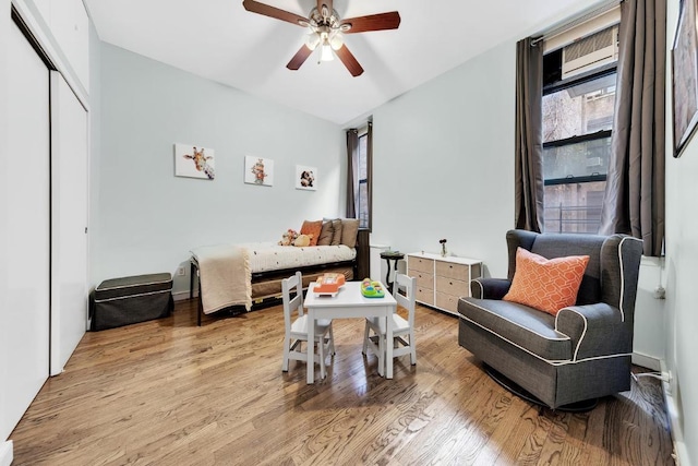 living area with ceiling fan and light hardwood / wood-style flooring