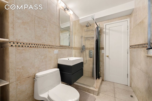 bathroom featuring tiled shower, tile patterned flooring, tile walls, and vanity