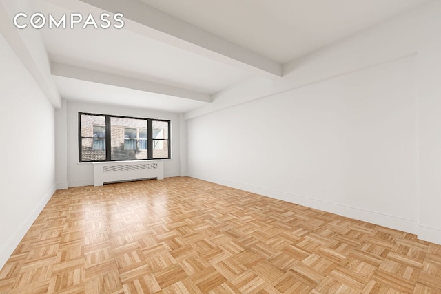 spare room with beamed ceiling, radiator, and light parquet floors