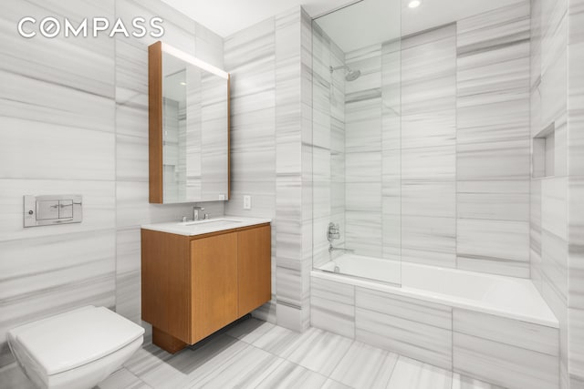 50 W St Unit 14B, New York City, NY 10006 - full bath with tiled shower / bath combo, tile patterned floors, vanity, tile walls, and toilet