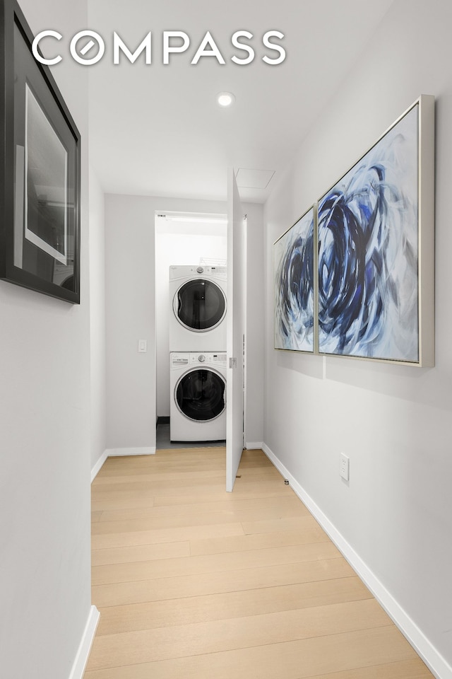 50 W St Unit 14B, New York City, NY 10006 - washroom with stacked washer / drying machine, light wood-type flooring, baseboards, and recessed lighting