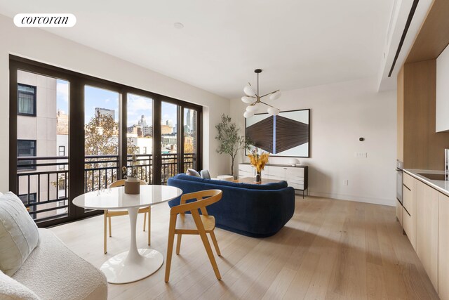 dining area with a notable chandelier, sink, and light wood-type flooring