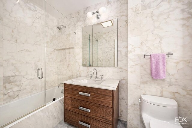 bathroom with toilet, tile walls, shower / tub combination, and vanity