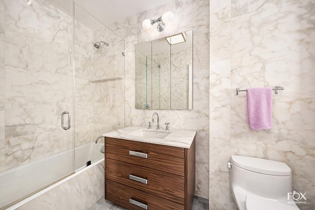 full bathroom featuring tile walls, tiled shower / bath combo, vanity, and toilet