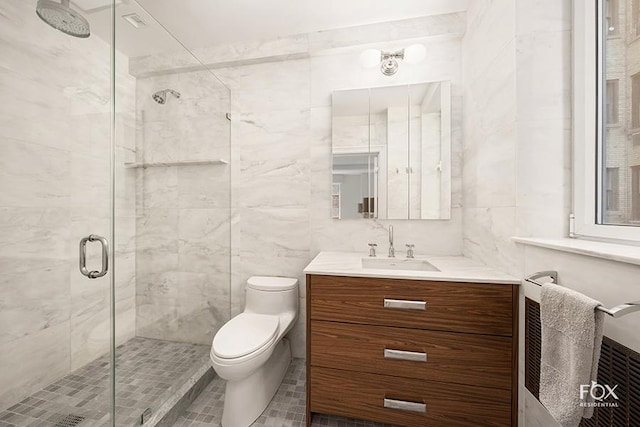 full bathroom with toilet, a shower stall, tile walls, and vanity