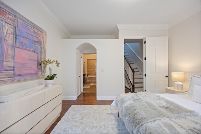 bedroom featuring arched walkways, ornamental molding, dark wood finished floors, and baseboards