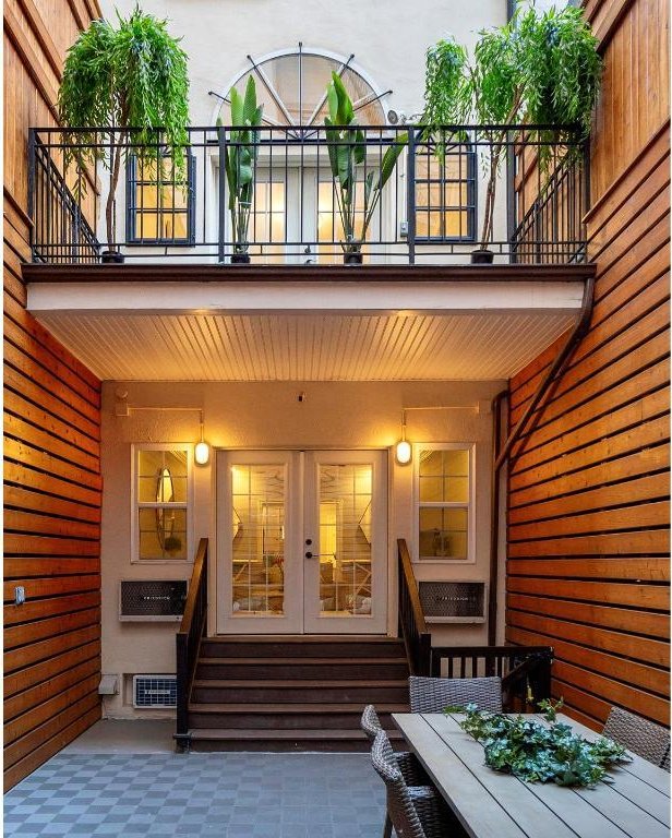 bedroom with hardwood / wood-style floors, crown molding, and a wall unit AC