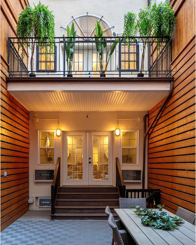 exterior space with entry steps, french doors, visible vents, and a balcony