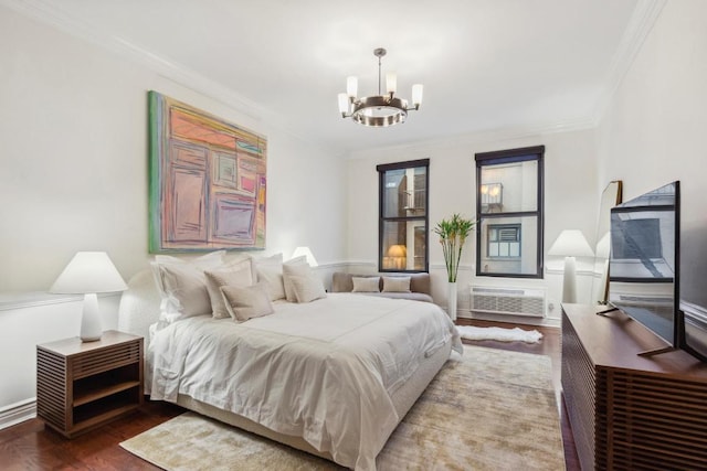 bedroom featuring an inviting chandelier, ornamental molding, wood-type flooring, and a wall mounted air conditioner