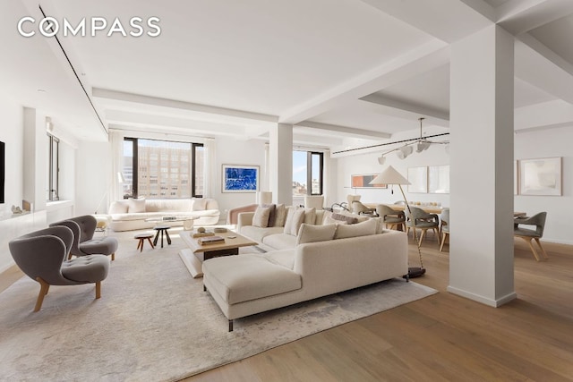 living room featuring beamed ceiling and wood-type flooring