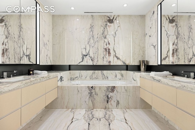 bathroom with vanity and tiled bath