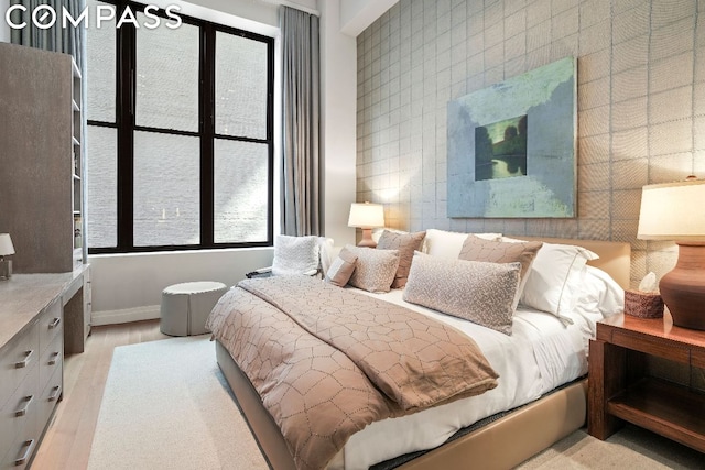 bedroom with tile walls and light hardwood / wood-style floors