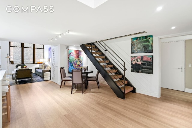 dining space featuring stairs, light wood finished floors, rail lighting, and recessed lighting