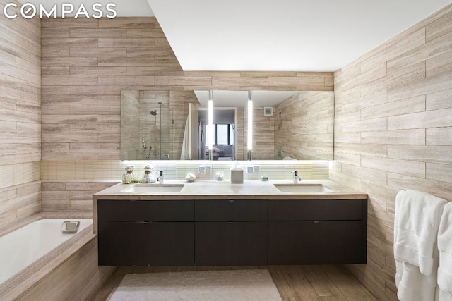 bathroom featuring tile walls, vanity, and plus walk in shower