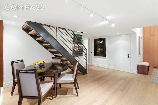 dining room with light wood-type flooring, baseboards, stairway, and recessed lighting