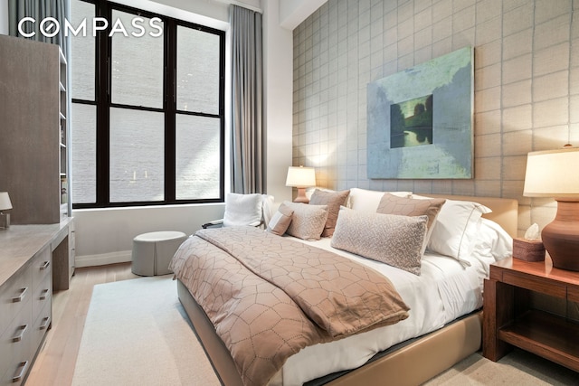 bedroom with wood finished floors, tile walls, and baseboards