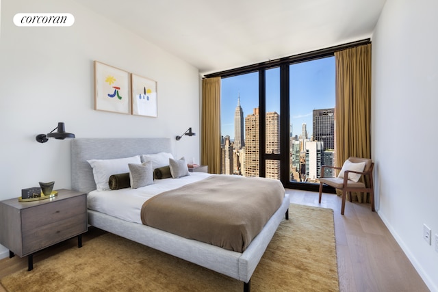 bedroom featuring floor to ceiling windows and hardwood / wood-style floors