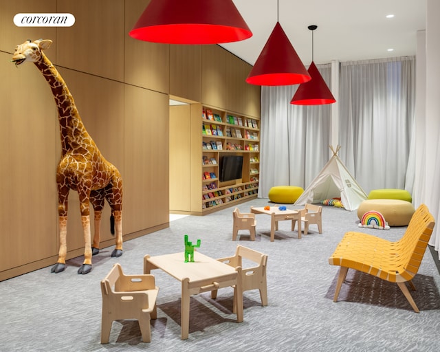 game room with a towering ceiling and light carpet