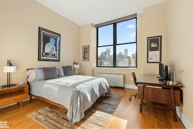 bedroom featuring radiator and wood-type flooring