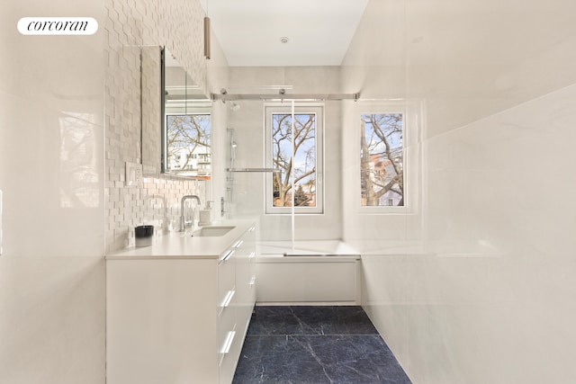 bathroom featuring vanity, visible vents, tile walls, decorative backsplash, and a bathtub