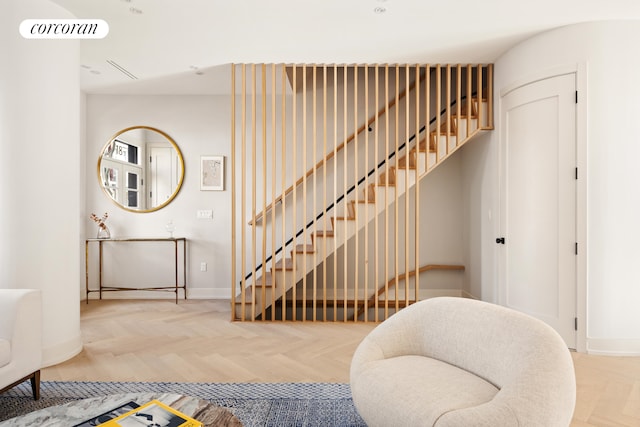 stairway featuring baseboards and visible vents