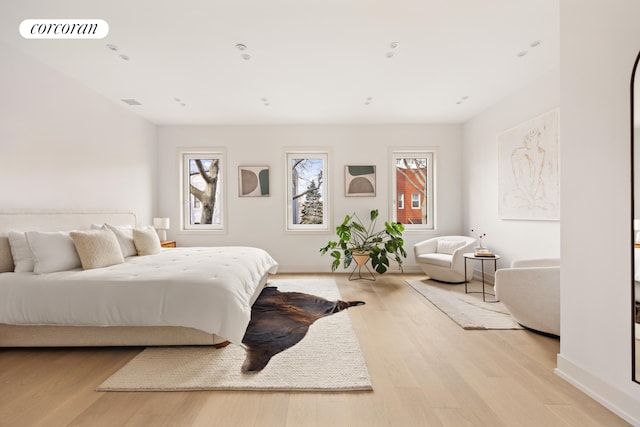 bedroom with light wood finished floors, baseboards, and visible vents