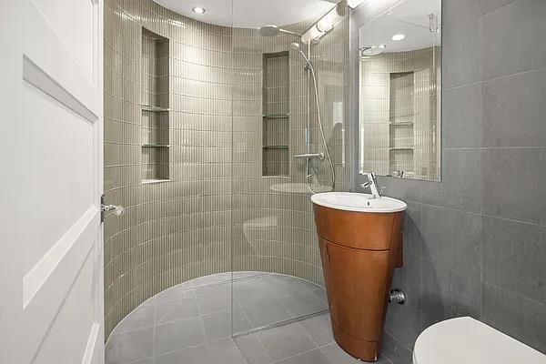 bathroom with walk in shower, toilet, and vanity