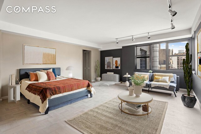 bedroom featuring baseboards, a view of city, and track lighting